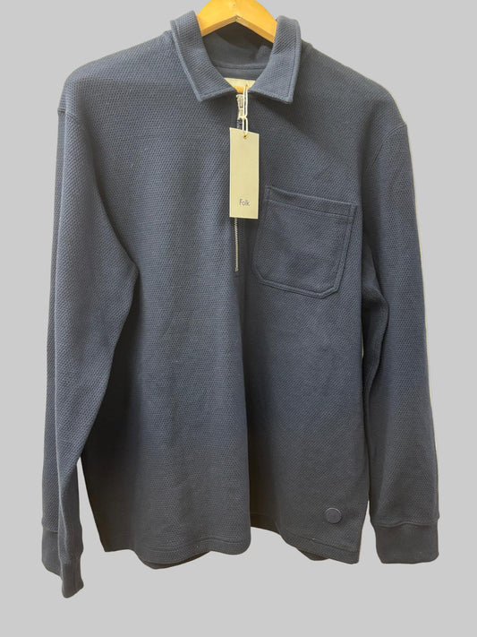 Blue jacket with a tag on a hanger against a beige background