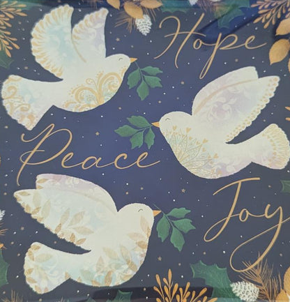 A square decorative item in a clear plastic sleeve, featuring a navy blue background with white dove illustrations, gold script text, and green leaf accents, placed on a light wood surface next to a black keyboard.