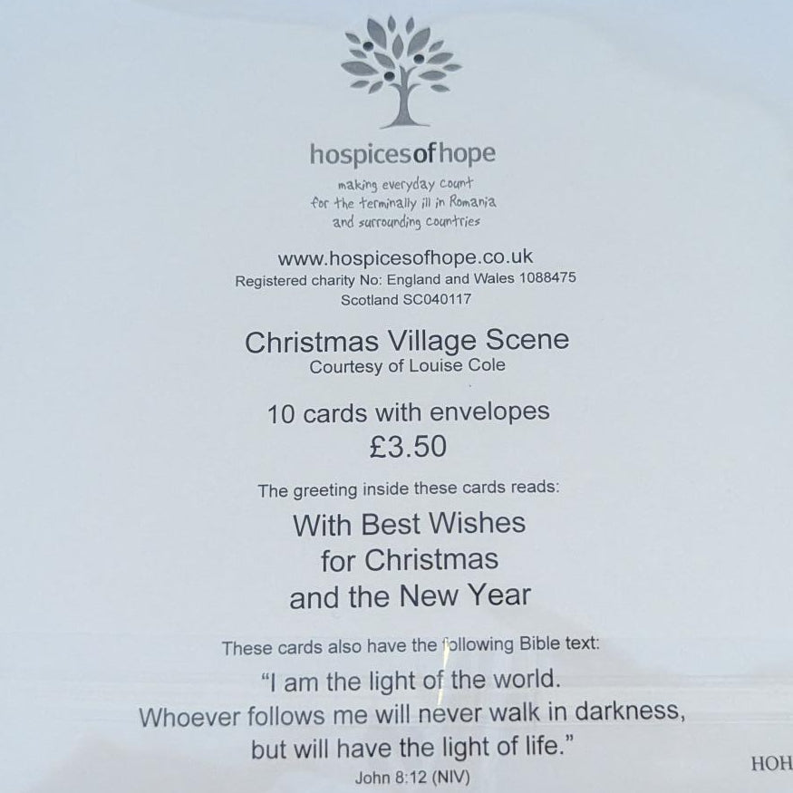 A white printed card or booklet insert enclosed in a clear plastic sleeve, photographed from above on a light wood surface. The card contains small black text and a floral logo near the bottom right.